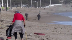 Un grup de voluntaris estrangers neteja la platja de Platja d'Aro després del temporal
