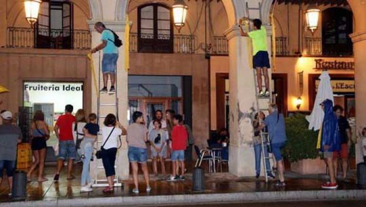 Un centenar de veïns de La Bisbal tornen a penjar els llaços grocs al municipi