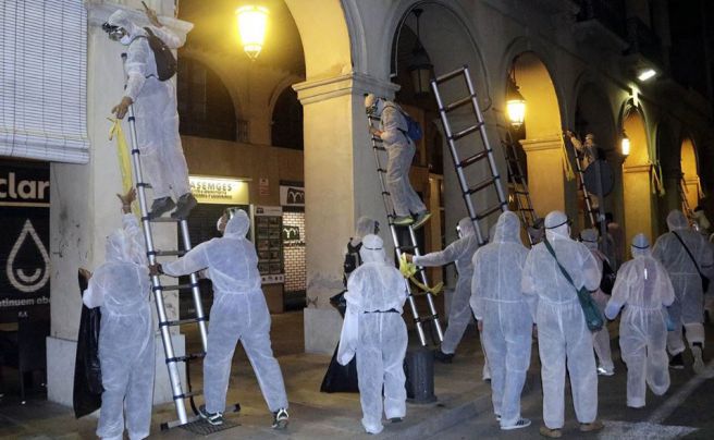 Una vuitantena de persones encaputxades retiren llaços grocs al Baix Empordà